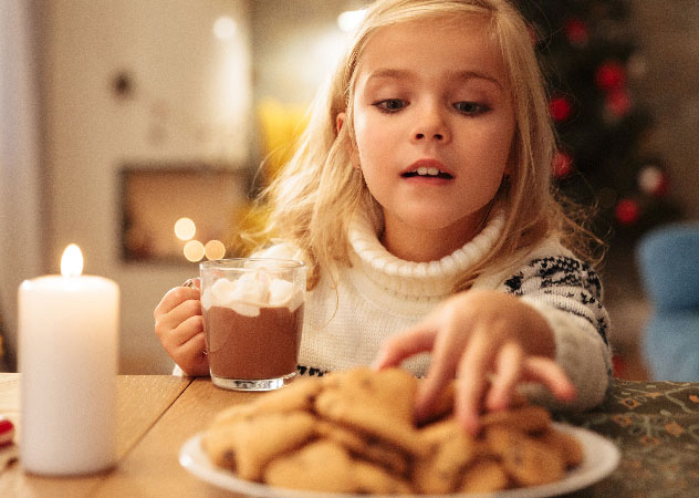 Mädchen mit Kakao und Weihnachtsplätzchen – Team Klima