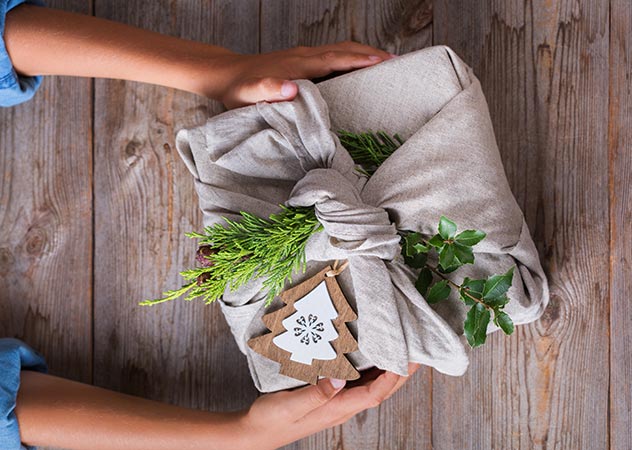 Nachhaltig verpacktes Weihnachtsgeschenk mit Kinderhänden